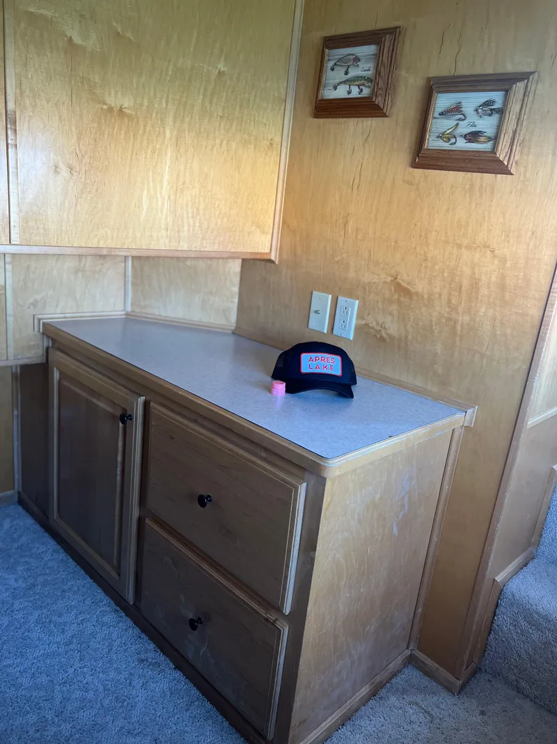 Slide: The Image of Wooden interior of a 2002 Sharpe houseboat with cabinets and framed fish artwork. - 14