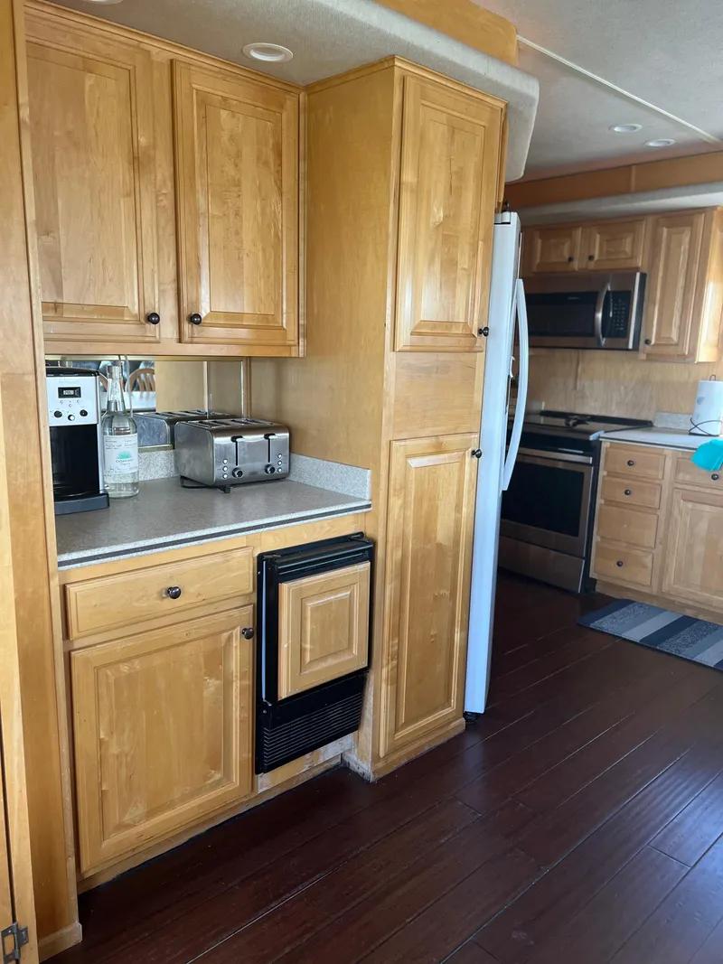 Slide: The Image of Kitchen interior of a 2002 Sharpe houseboat with wooden cabinets and modern appliances. - 16