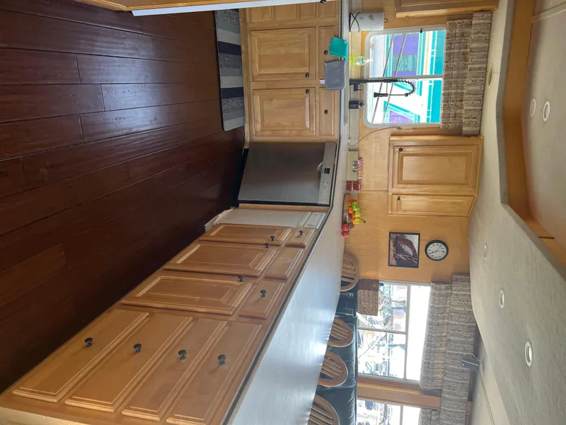 Slide: The Image of Interior kitchen of a 2002 Sharpe houseboat with wooden cabinets and flooring. - 17