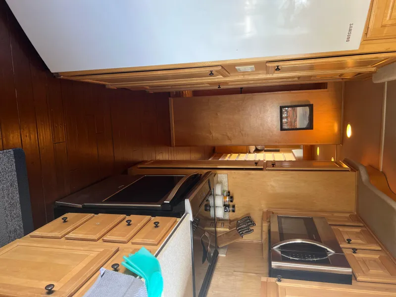 Slide: The Image of Interior of 2002 Sharpe houseboat kitchen with wooden cabinets and modern appliances. - 18
