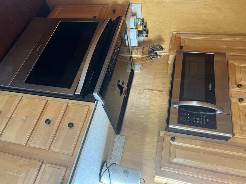Slide: The Image of Kitchen interior of a 2002 Sharpe houseboat with modern appliances and wooden cabinetry. - 19
