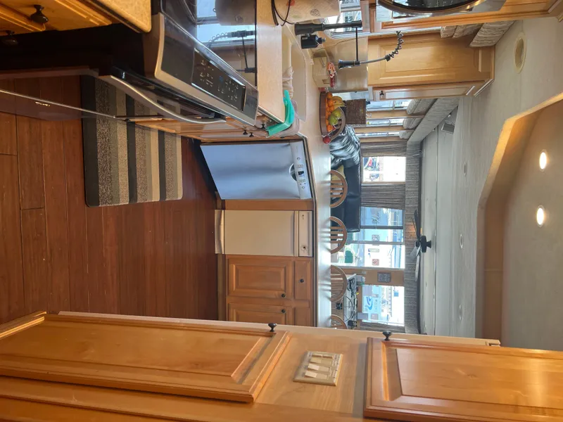 Slide: The Image of Interior of a 2002 Sharpe houseboat kitchen with wooden cabinets and modern appliances. - 20