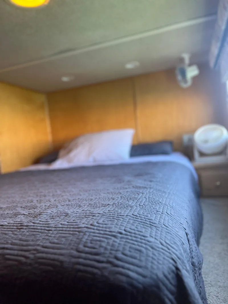 Slide: The Image of Cozy bedroom in a 2002 Sharpe houseboat with a neatly made bed and wooden walls. - 24