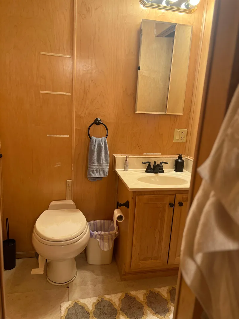 Slide: The Image of Small bathroom in a 2002 Sharpe houseboat with wooden walls and modern fixtures. - 27