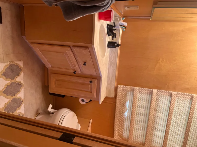 Slide: The Image of Bathroom interior of a 2002 Sharpe houseboat with wooden cabinets and a toilet. - 29