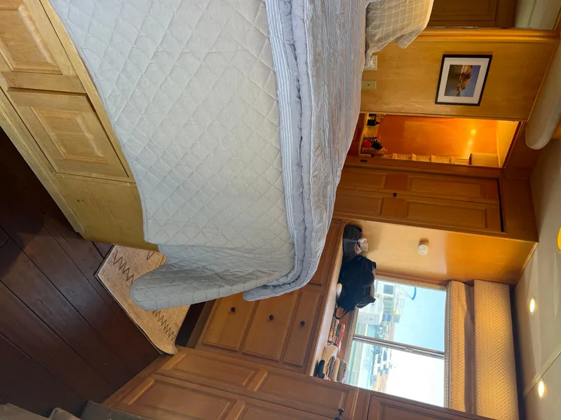 Slide: The Image of Interior of a 2002 Sharpe houseboat bedroom with wooden cabinetry and a large bed. - 35