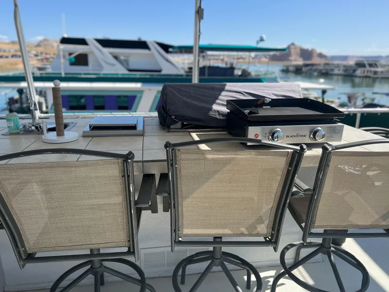 Slide: The Image of Outdoor dining area on 2002 Sharpe houseboat with grill and chairs, docked at marina. - 40