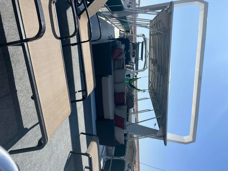 Slide: The Image of 2002 Sharpe houseboat deck with seating and canopy under clear blue sky. - 48