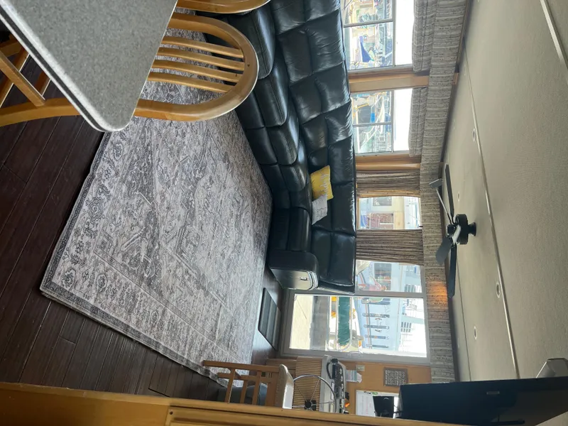 Slide: The Image of Interior of 2002 Sharpe houseboat with leather sofa, rug, and large windows. - 8