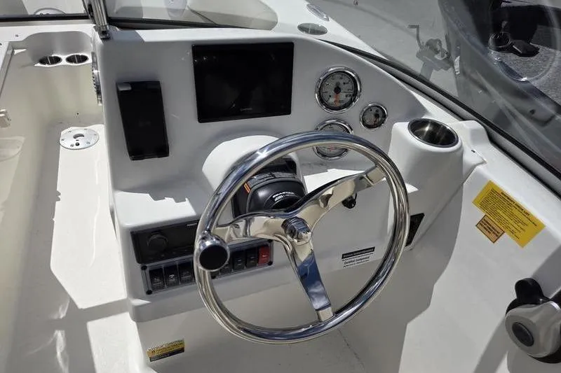 Slide: The Image of 2025 Key West 203 DFS boat dashboard with steering wheel and gauges. - 10