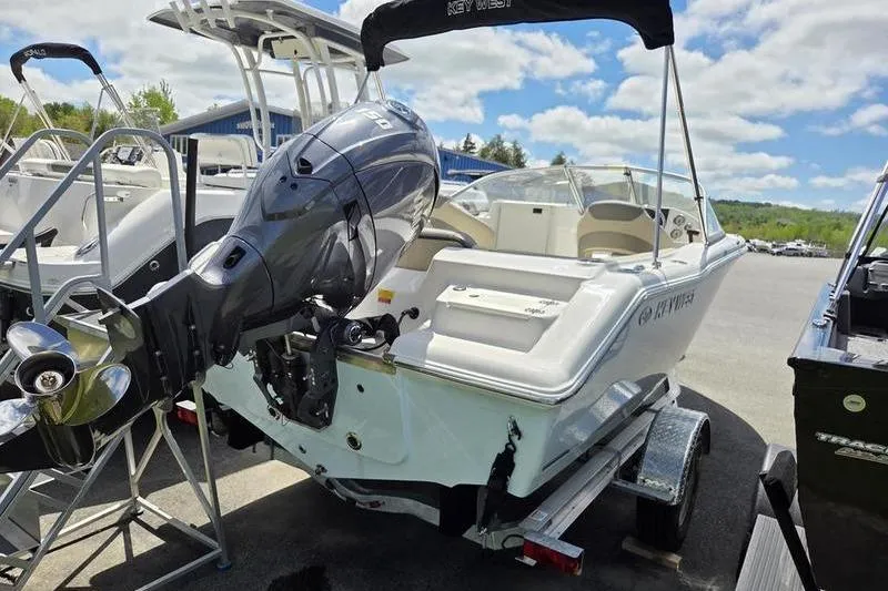 Slide: The Image of 2025 Key West 203 DFS boat on trailer with outboard motor, under a sunny sky. - 5