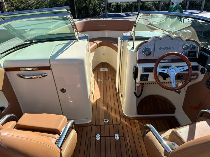 Slide: The Image of 2013 Chris-Craft Launch 25 boat interior with Garmin navigation, wood flooring, and leather seats. - 11