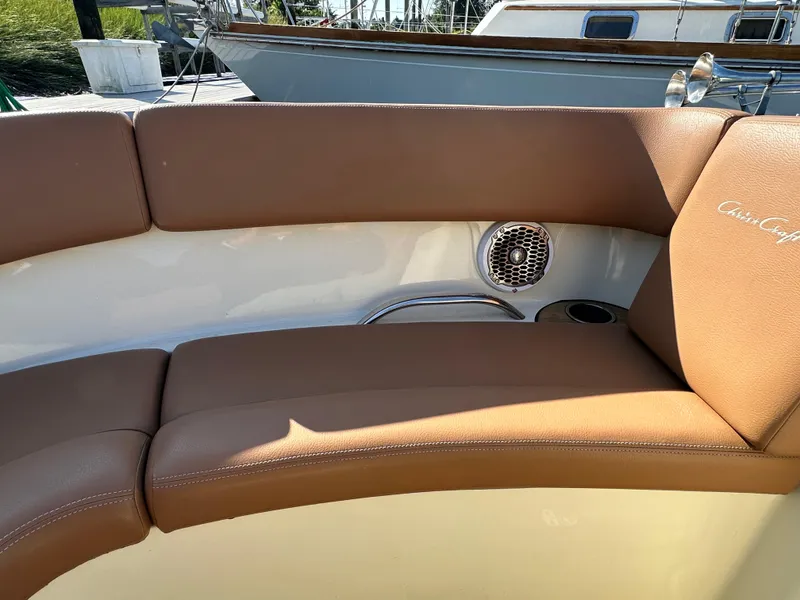 Slide: The Image of 2013 Chris-Craft Launch 25 boat interior with brown leather seating and speaker. - 13