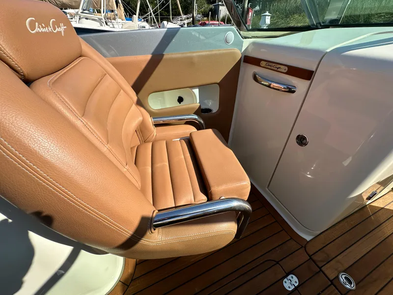 Slide: The Image of 2013 Chris-Craft Launch 25 boat interior with tan leather seat and wooden deck. - 18