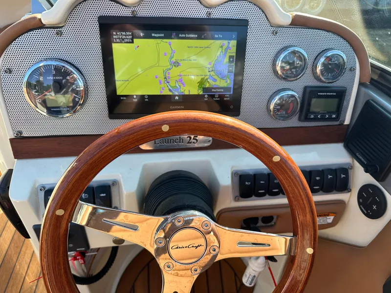 Slide: The Image of Dashboard of 2013 Chris-Craft Launch 25 boat with navigation system and wooden steering wheel. - 20