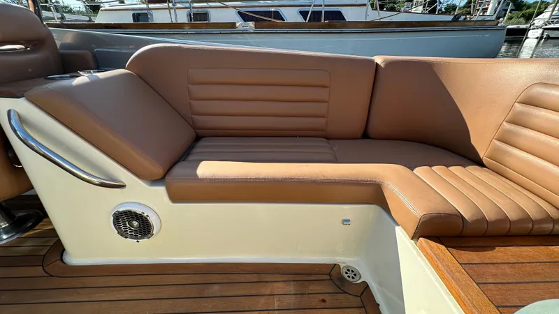 Slide: The Image of 2013 Chris-Craft Launch 25 boat interior with tan leather seating and wooden deck. - 22