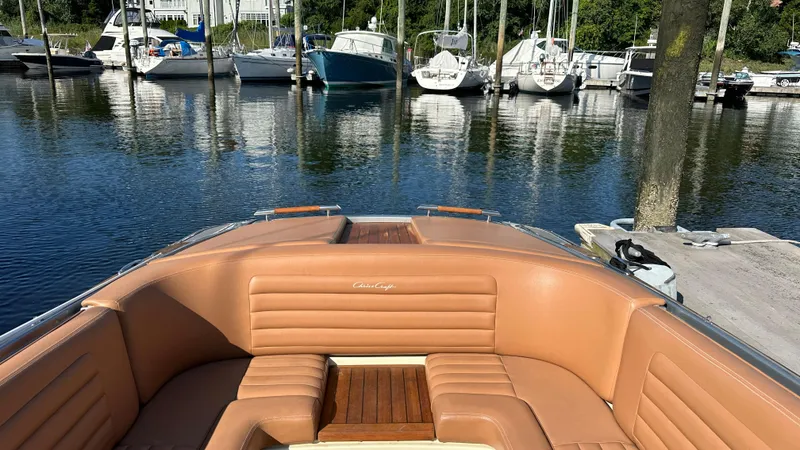 Slide: The Image of 2013 Chris-Craft Launch 25 boat with tan leather seating, docked in a marina. - 24