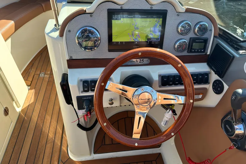 Slide: The Image of Dashboard of 2013 Chris-Craft Launch 25 with wooden steering wheel and navigation display. - 26