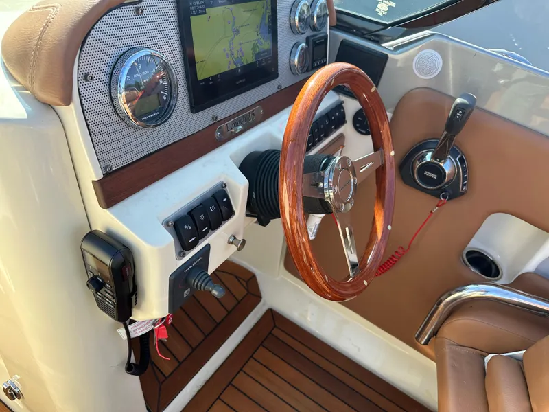 Slide: The Image of 2013 Chris-Craft Launch 25 boat dashboard with wooden steering wheel and navigation system. - 5