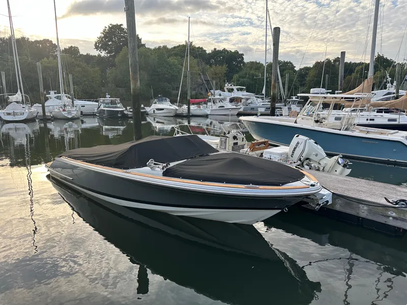 Slide: The Image of 2013 Chris-Craft Launch 25 boat docked in a marina with other vessels. - 6