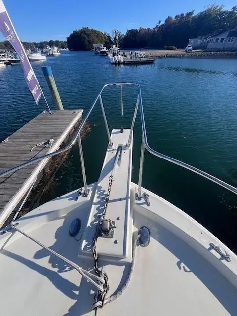Slide: The Image of 1989 Blue Seas Out Island Explorer boat docked at marina, calm water, clear sky. - 11