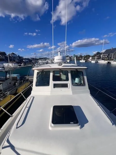 Slide: The Image of 1989 Blue Seas Out Island Explorer boat docked in a marina under a clear blue sky. - 12