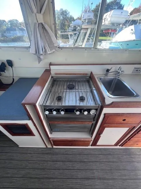 Slide: The Image of 1989 Blue Seas Out Island Explorer kitchen with stove, sink, and wooden cabinetry. - 18