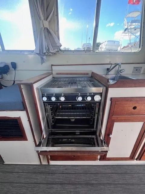 Slide: The Image of 1989 Blue Seas Out Island Explorer boat kitchen with open oven and sink. - 19