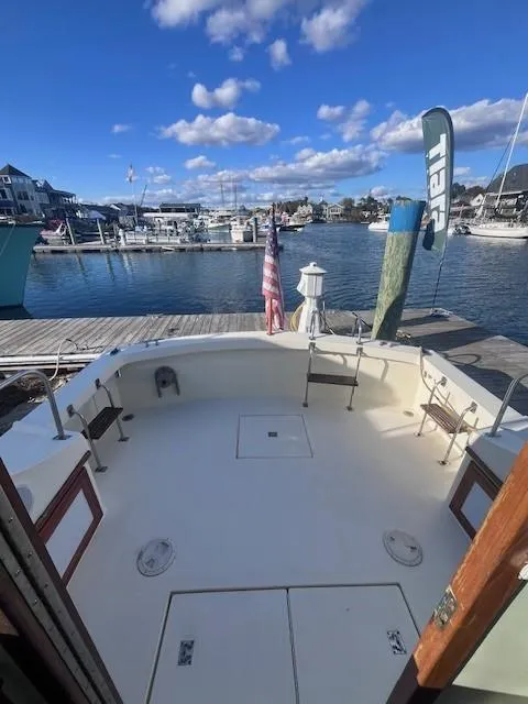 Slide: The Image of 1989 Blue Seas Out Island Explorer docked at a marina under a clear blue sky. - 28