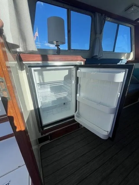 Slide: The Image of 1989 Blue Seas Out Island Explorer interior with open mini fridge, wooden accents, and window view. - 30
