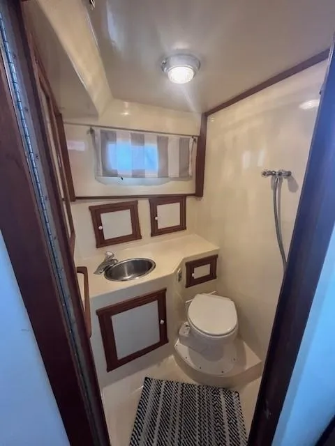 Slide: The Image of 1989 Blue Seas Out Island Explorer boat bathroom with sink, toilet, and shower. - 33