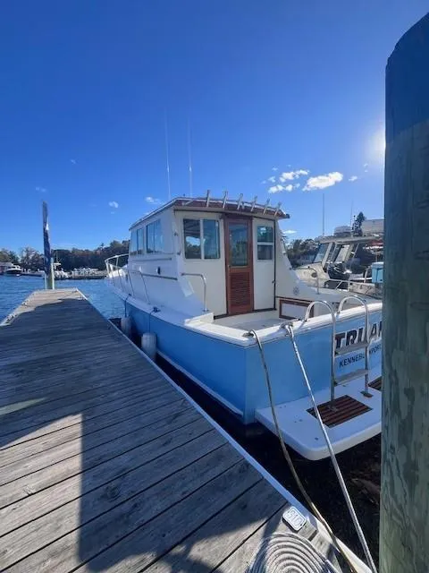 Slide: The Image of 1989 Blue Seas Out Island Explorer docked at marina under clear blue sky. - 4