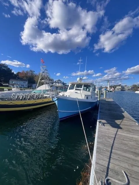 Slide: The Image of 1989 Blue Seas Out Island Explorer docked under a vibrant blue sky. - 5