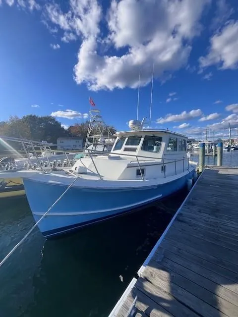 Slide: The Image of 1989 Blue Seas Out Island Explorer docked under a bright blue sky. - 6