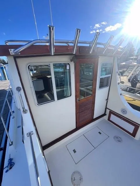 Slide: The Image of 1989 Blue Seas Out Island Explorer boat deck with wooden door and rod holders. - 7