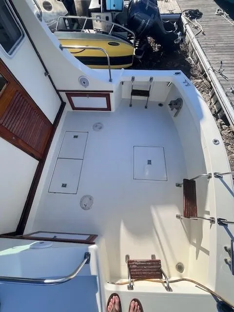 Slide: The Image of 1989 Blue Seas Out Island Explorer boat deck with wooden accents and storage compartments. - 9