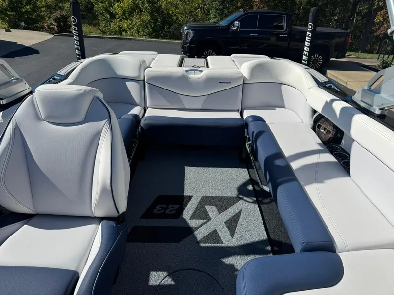 Slide: The Image of 2019 MasterCraft XT23 boat interior with white and blue seating. - 11