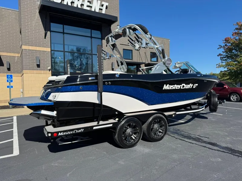 Slide: The Image of 2019 MasterCraft XT23 boat on trailer, parked outside a building. - 3