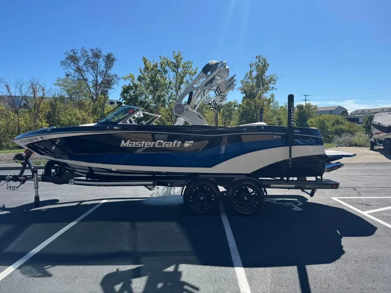 Slide: The Image of 2019 MasterCraft XT23 boat on trailer in sunny parking lot. - 6