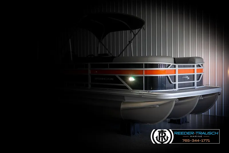 Slide: The Image of 2025 Bennington 21 SSBSE pontoon boat with orange stripe, displayed indoors at Reeder-Trausch Marine. - 4