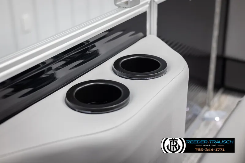 Slide: The Image of 2025 Bennington 21 SSBSE boat interior with dual cup holders, Reeder-Trausch Marine logo. - 40