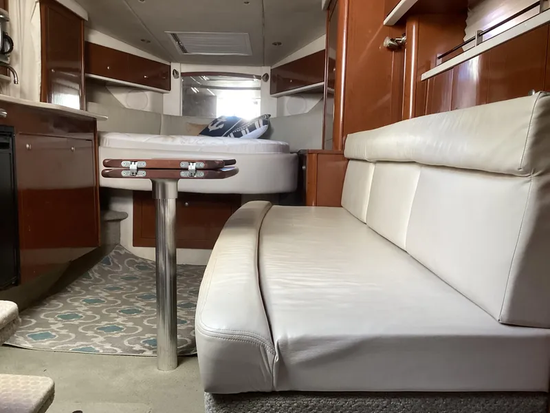 Slide: The Image of Interior of 2008 Sea Ray 350 Sundancer with white leather seating and wooden cabinetry. - 15