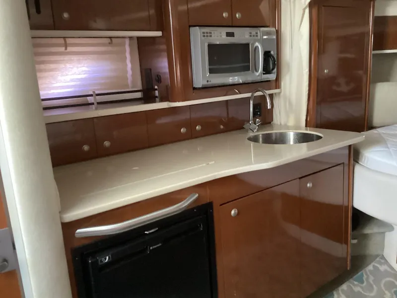 Slide: The Image of 2008 Sea Ray 350 Sundancer kitchen with microwave, sink, and compact fridge. - 18