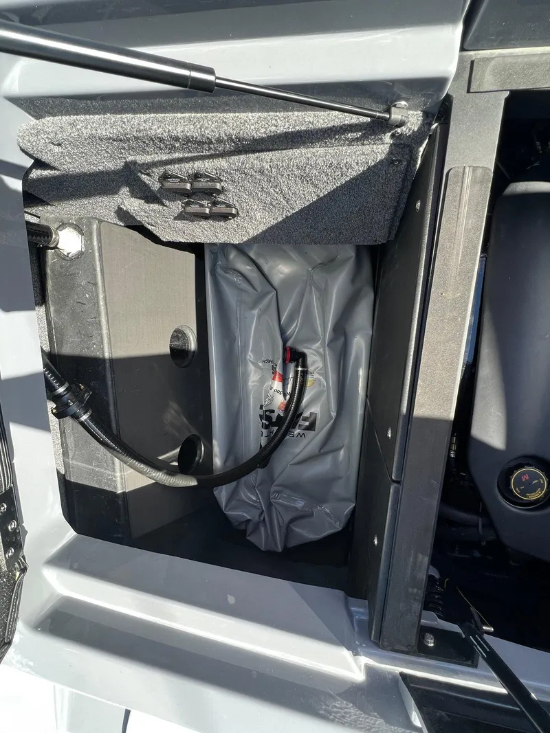 Slide: The Image of 2023 Malibu Wake Setter LSV 22 storage compartment with ballast bag and hose. - 14