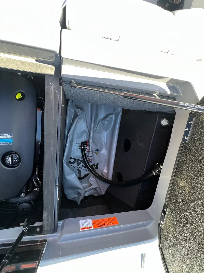 Slide: The Image of 2023 Malibu Wake Setter LSV 22 storage compartment with engine and ballast bag. - 15