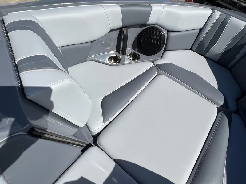 Slide: The Image of 2023 Malibu Wake Setter LSV 22 interior with gray and white seating, cup holders, and speaker. - 24