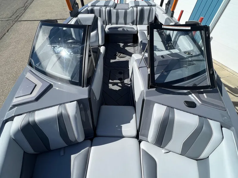 Slide: The Image of 2023 Malibu Wake Setter LSV 22 boat interior with gray seating and open windshield. - 25