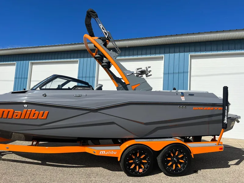 Slide: The Image of 2023 Malibu Wake Setter LSV 22 boat on trailer, gray and orange design. - 36