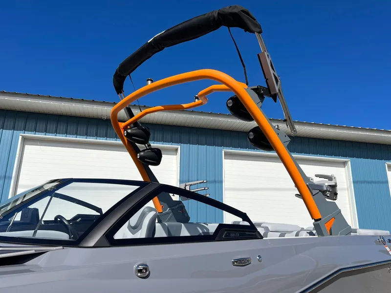 Slide: The Image of 2023 Malibu Wake Setter LSV 22 boat with orange wakeboard tower against blue sky. - 39