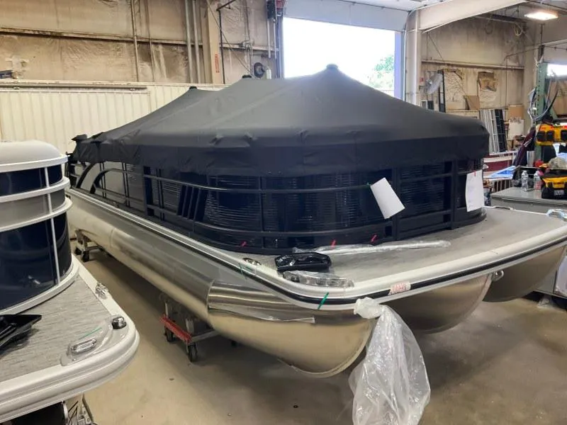 Slide: The Image of 2023 Bennington 21LSB pontoon boat with cover in a storage facility. - 1